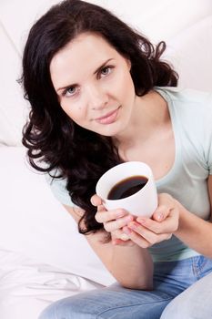 smiling brunette woman drinking black coffee in the morning