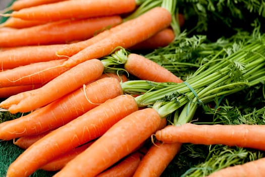 fresh orange carrot bundle on market in summer outdoor