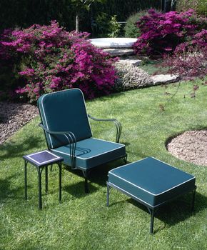 Garden chair on green grass with a jacuzzi in background