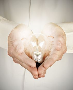 Hands holding light bulb