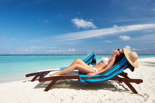 Young woman in chaise lounge at the beach