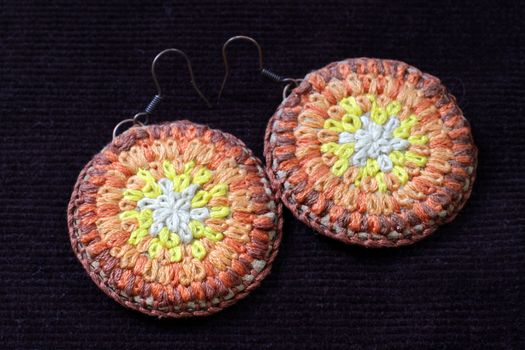 Knitted earrings on a velvet background. Handmade.