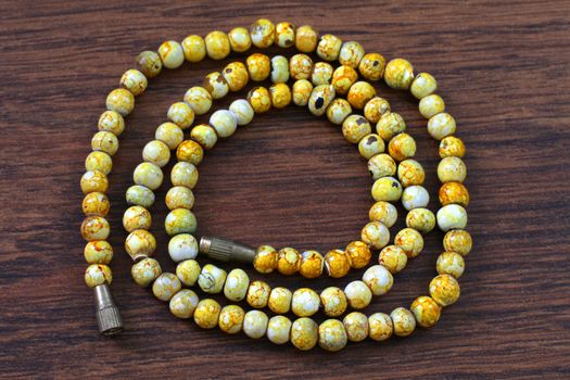 yellow plastic beads on brown background