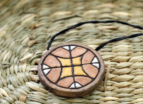Ethnic handmade clay amulet on the wooden table
