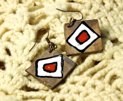 Wooden earrings in ethnic style on the knitted scarf