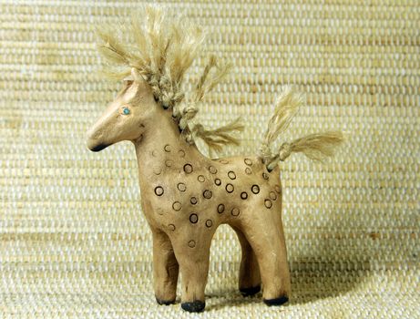 hand made clay toy ethnic horse on bamboo background