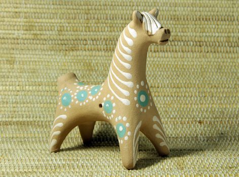 hand made clay ethnic horse toy on bamboo background