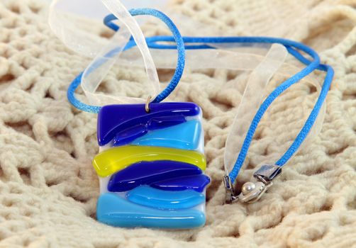 handmade necklace of blue glass flowers on knitted scarf