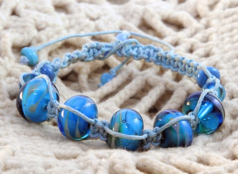 Blue beaded bracelet on the knitted background
