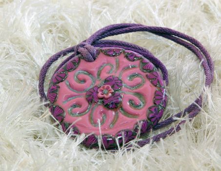 clay handmade red and violet flower on a knitted background