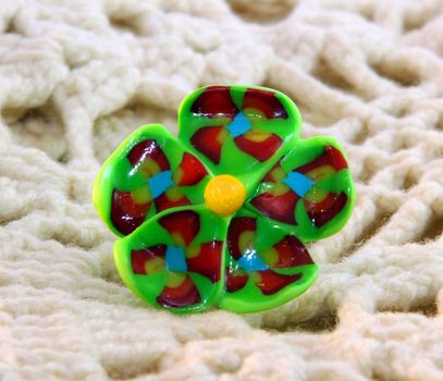 clay ring green flower handmade on the knitted scarf