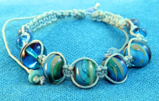 Blue beaded bracelet on the blue knitted background