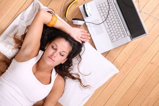 A girl laying on the Floor after surfing on the Internet with a Laptop.