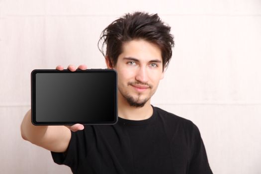 A young hispanic man holding a Tablet PC.