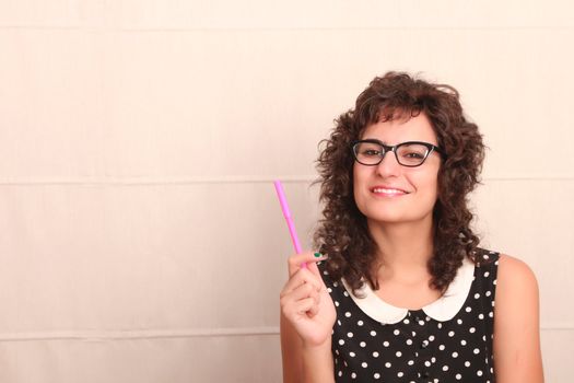 A young woman in a vintage dress holding a pen.