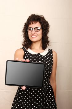 A young woman in a Retro dress holding a Tablet PC.