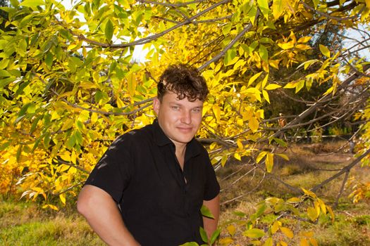 man in a black shirt on the background of autumn