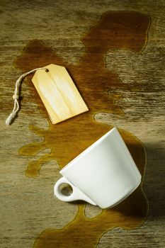 spilled coffee from a white cup on a grunge table with room for text