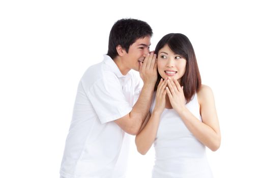 Portrait of young man whispering a secret to woman isolated on white background.