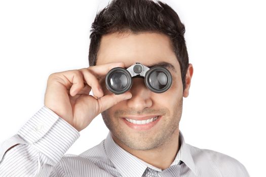Happy young businessman looking through binocular isolated on white background.