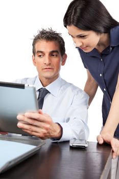 Businessman and businesswoman looking at digital tablet at work.