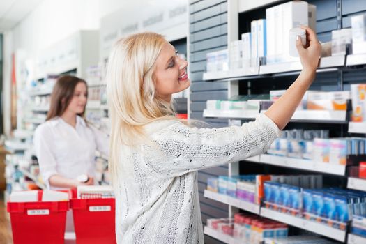 Happy woman buying medicine at pharmacy store