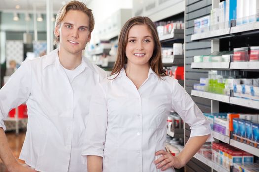 Portrait of male pharmacist technician standing with female colleague