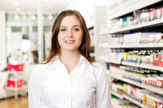 Portrait of a young attractive pharmacist looking at the camera in a pharmacy