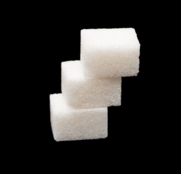 three lumps of sugar on a black background