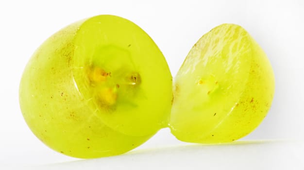 Translucent slice of green grape fruit, macro isolated on white 