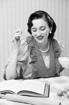 Young woman looking at a Recipe for a cake