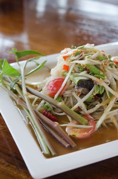 thai food , spicy papaya salad  and fresh vegetable on white plate