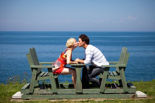 Romantic couple kissing and holding hands on the bench