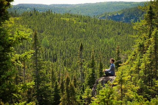 Young man on a rock in the middle of the nature