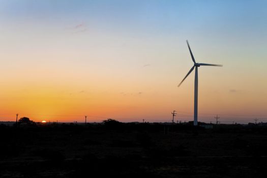 Horizontal image of barren land on the approach to Dwarka in Gujarat India. The sea breeze from the Arabian Sea is taken advantage of on plains with installation of wind powered generators for local infrastructure in the formm of electrical power
