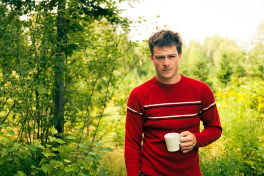 Man in nature with a mug of coffee