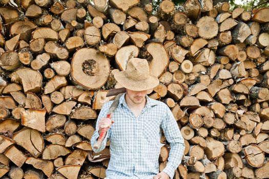 Woodcutter with straw hat on a background of wood