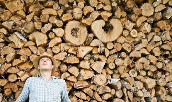 Woodcutter with straw hat on a background of wood taking a little break