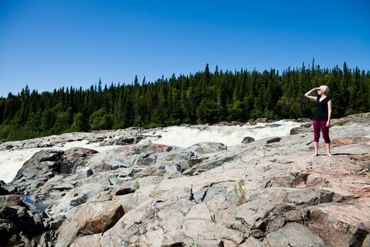 Young girl on a rock in the middle of the nature.