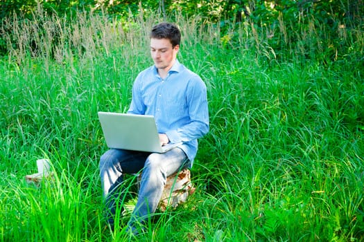 Young man typing outdoors using wireless technology