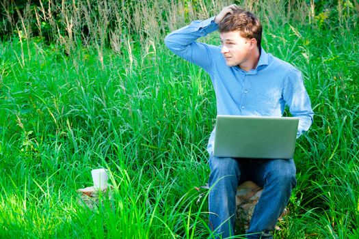 Lost man outdoors with a cup and laptop