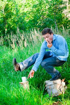 Young businessman in nature doing acrobatic poses