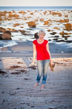 Girl walking along the beach and smiling at the camera