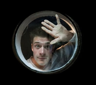 The young man looks the porthole