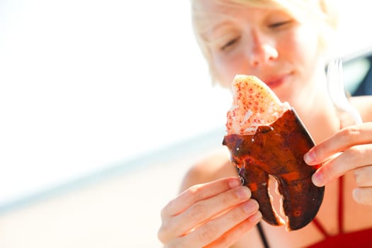 Girl holding a lobster claw outdoor with beautiful sunlight