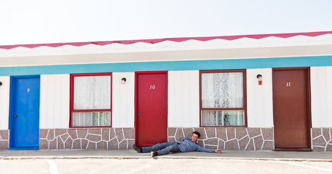 Motel and a man lying near the door