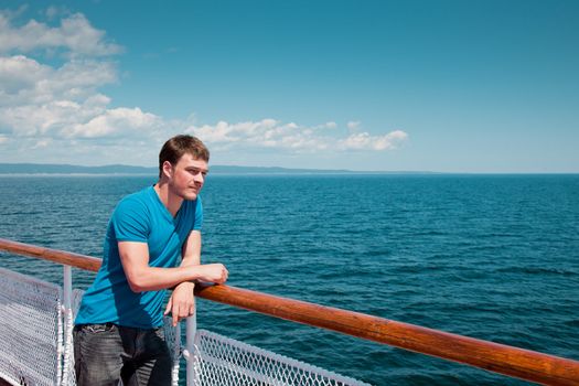 The young man on the deck against the sea