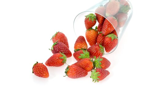 fresh strawberry spilling out of glass   on white background