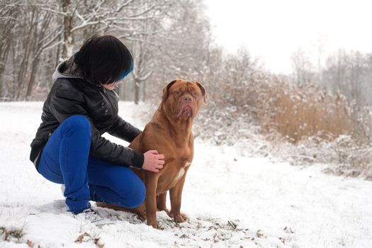 Funky boy is having fun with his dog in the snow