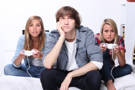 Three teenagers playing computer game